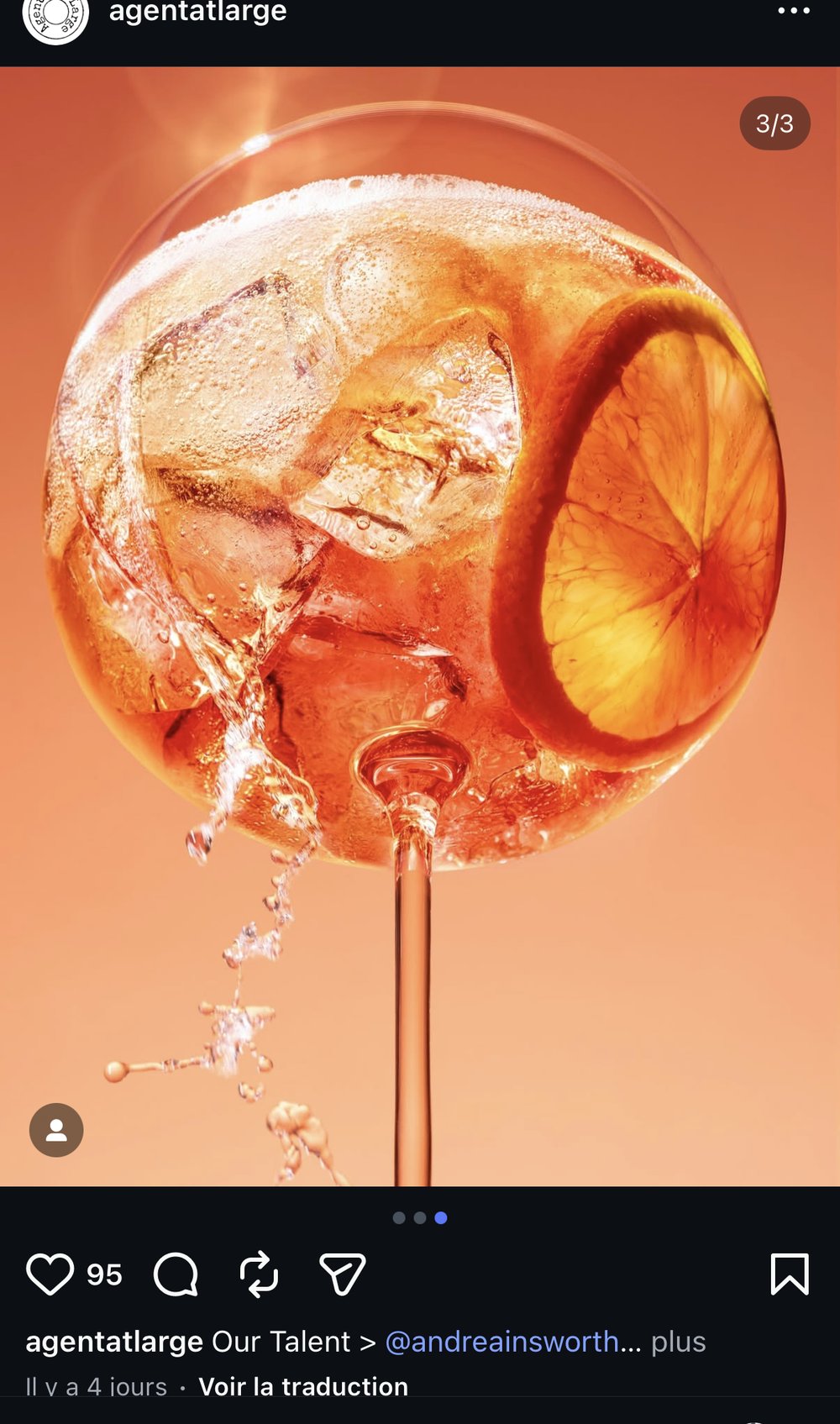 Cocktail en sphère de verre, rondelle d'agrume et glaçons, fond orange