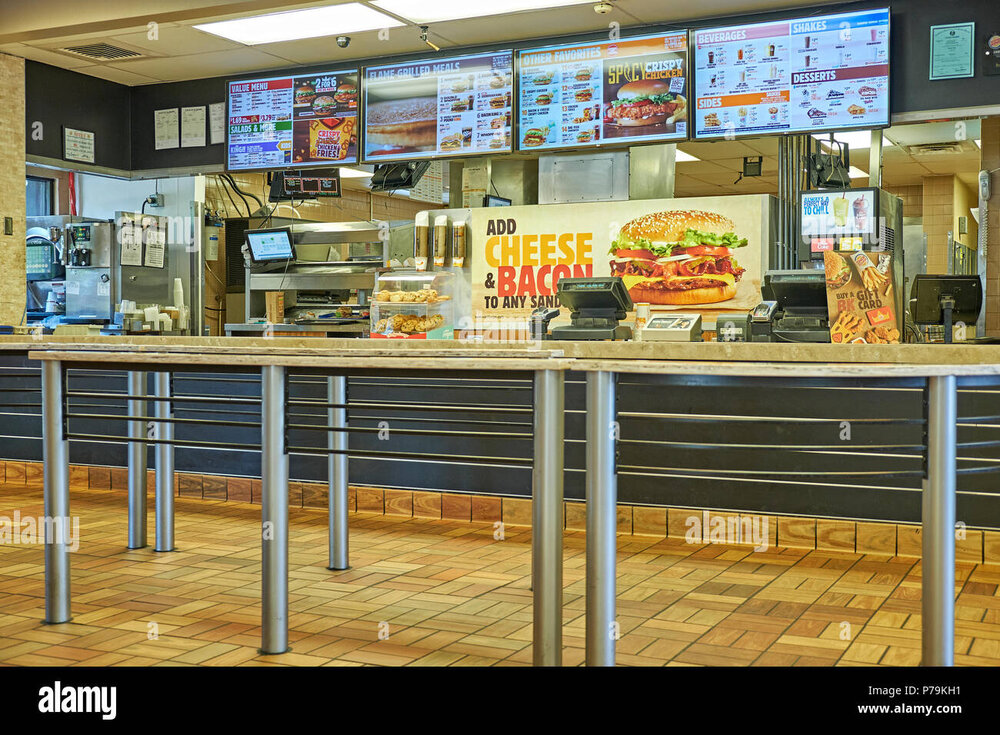 Comptoir Burger King finalisé — enseigne bois/noir, écrans « Retrait bornes / Paiement bornes / Caisses »