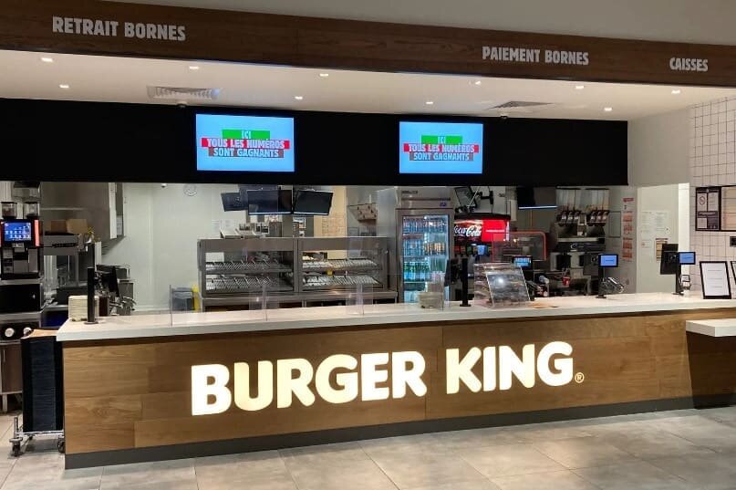 Comptoir Burger King classique rouge/jaune — écrans menu, King Junior, boissons en libre-service