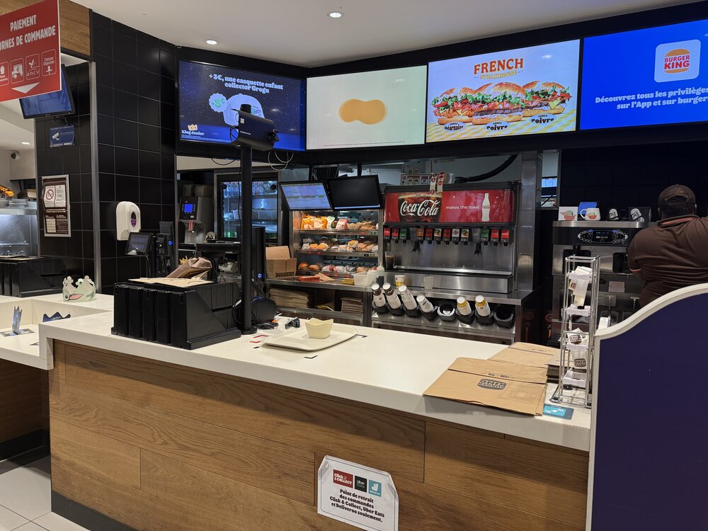 Comptoir de retrait Burger King — fontaine à sodas Coca-Cola, écrans menu « French », « King Fusion »