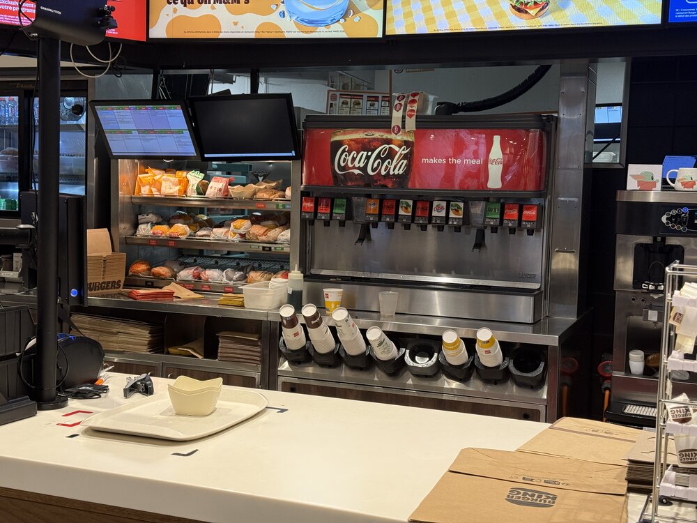 Totem comptoir « Home of the Burger » — lettrage néon orange sur fond violet