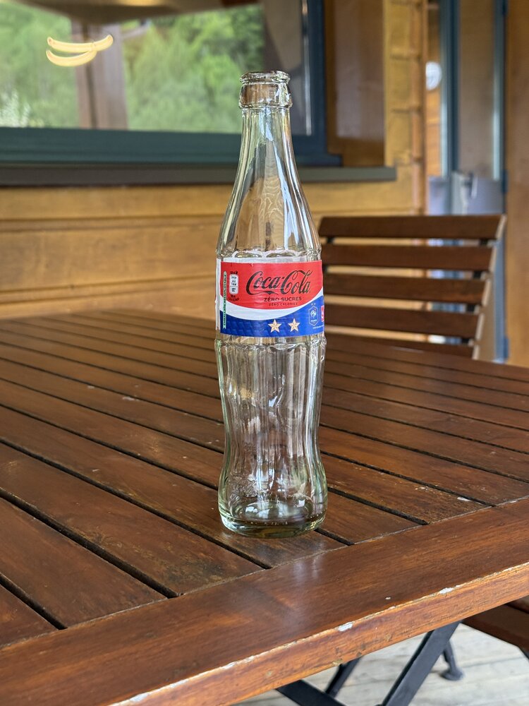 Bouteille verre Coca-Cola Zéro Sucres édition « France » — étiquette bleu-blanc-rouge, 2 étoiles, logo FFF « Partenaire officiel »