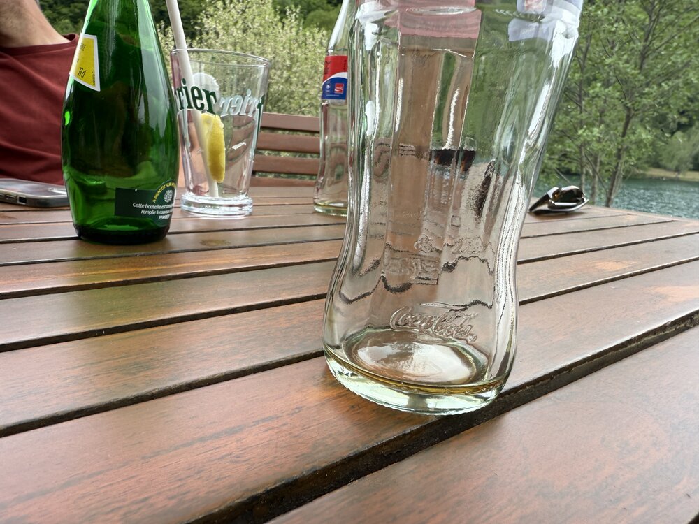 Bouteille vue de dessous — gravure du logo Coca-Cola historique dans le verre