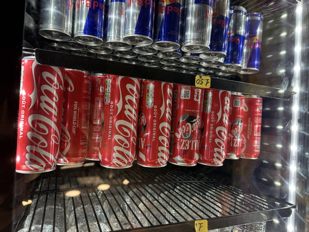 Meuble frigo Coca-Cola canettes rangees etiquettes prix