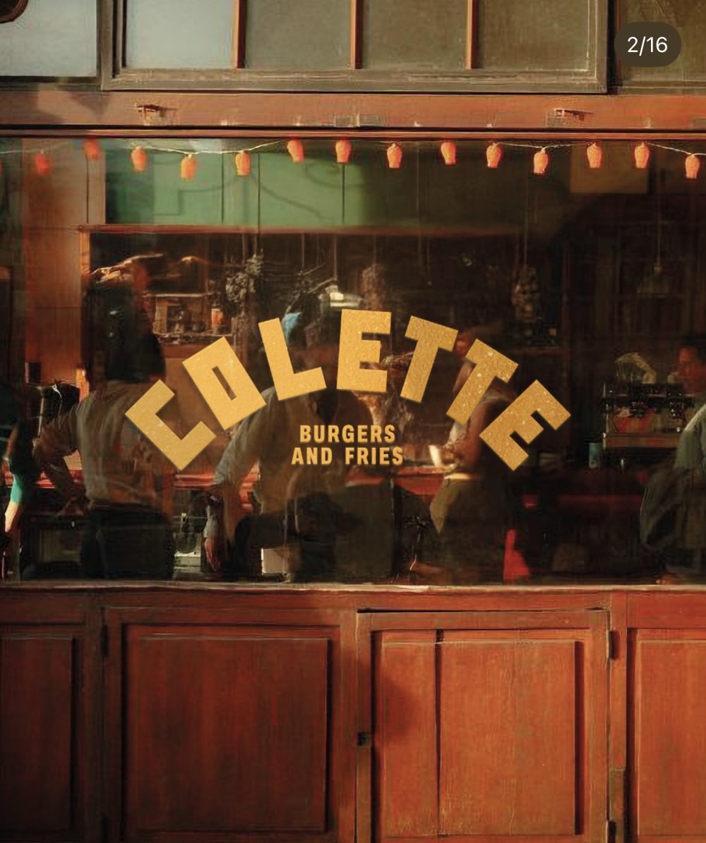 Vitrine — lettrage doré « COLETTE Burgers and fries » sur verrière, guirlande de lampions (Lot 25)