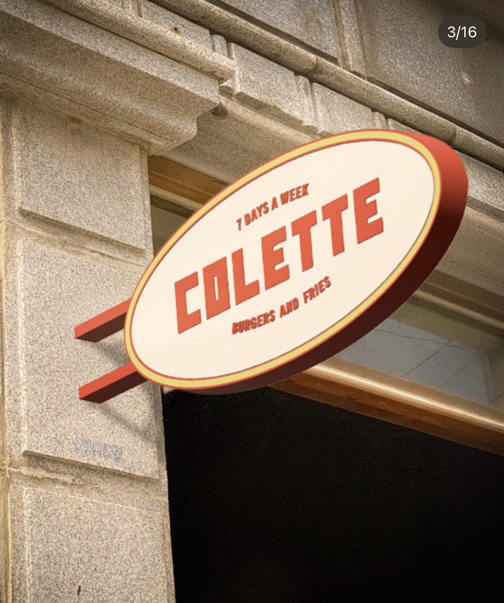 Enseigne ovale « COLETTE — 7 days a week — Burgers and fries » en applique sur façade pierre (Lot 25)