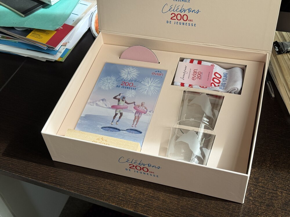 Coffret ouvert posé sur un bureau, texte « Célébrons 200 ans de jeunesse » imprimé sur le couvercle