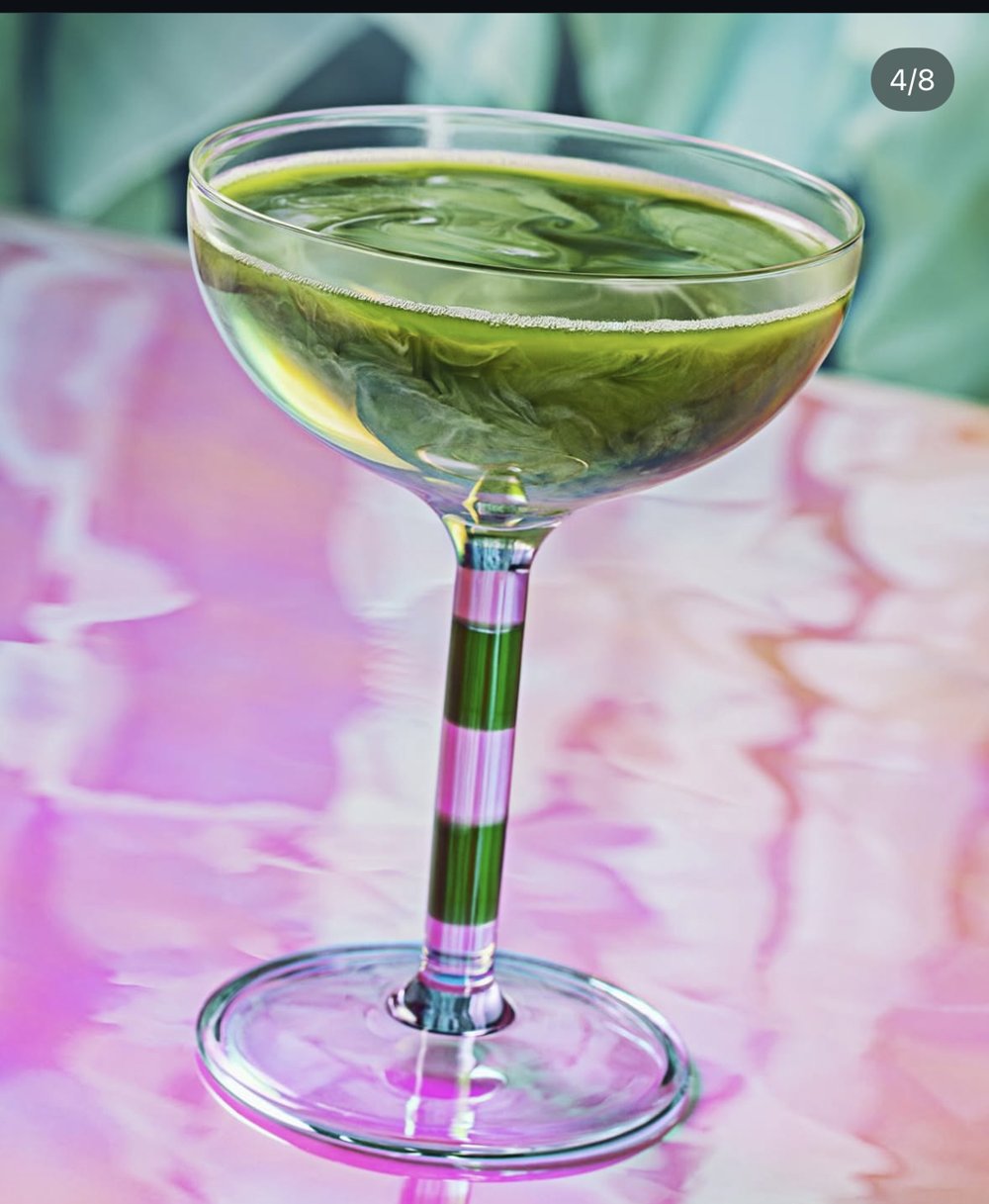 Cocktail vert nacré sur table irisée rose, mise en scène publicitaire