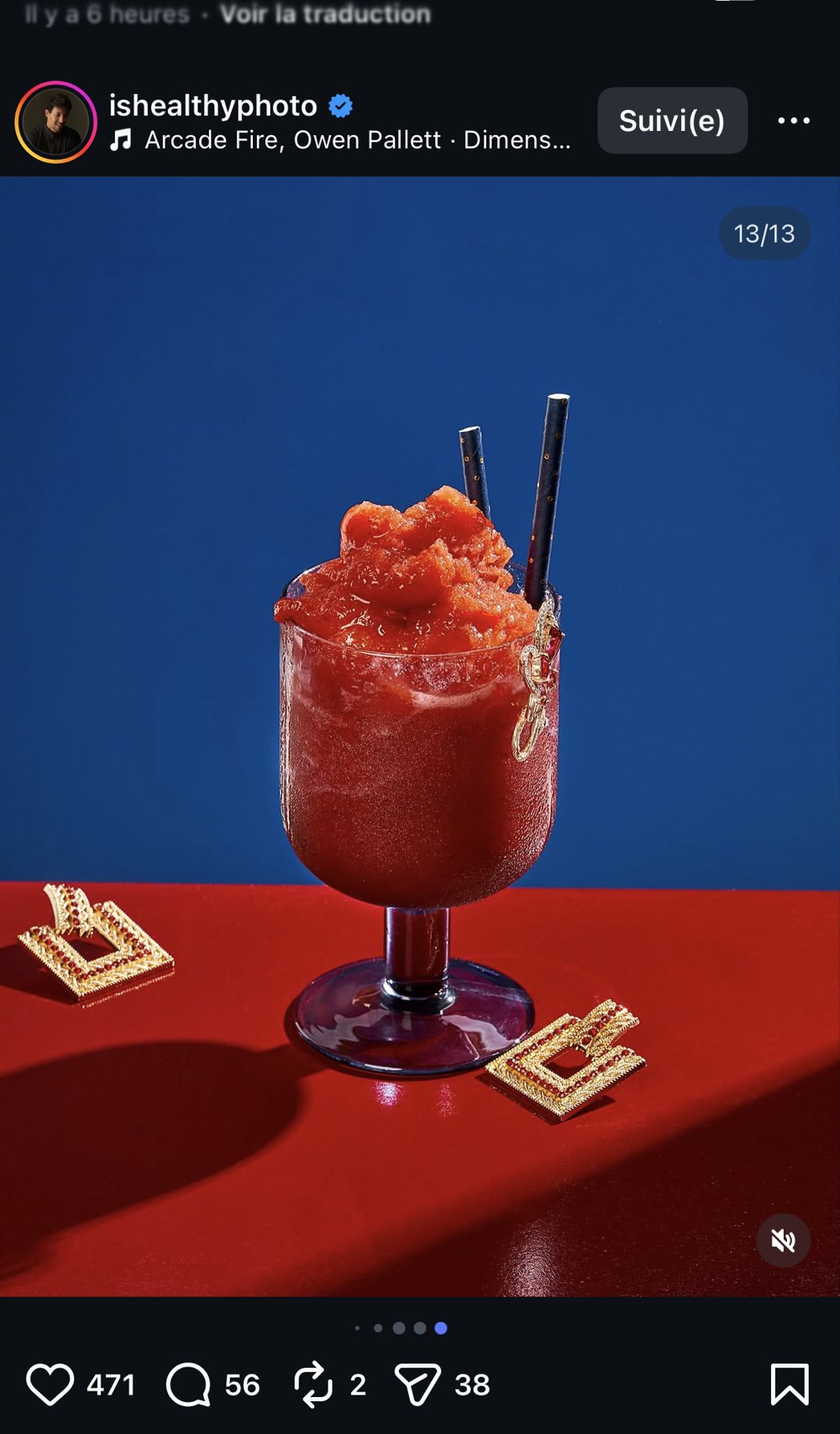 Cocktail rouge glacé pilé avec boucles d'oreilles dorées, fond bicolore bleu/rouge