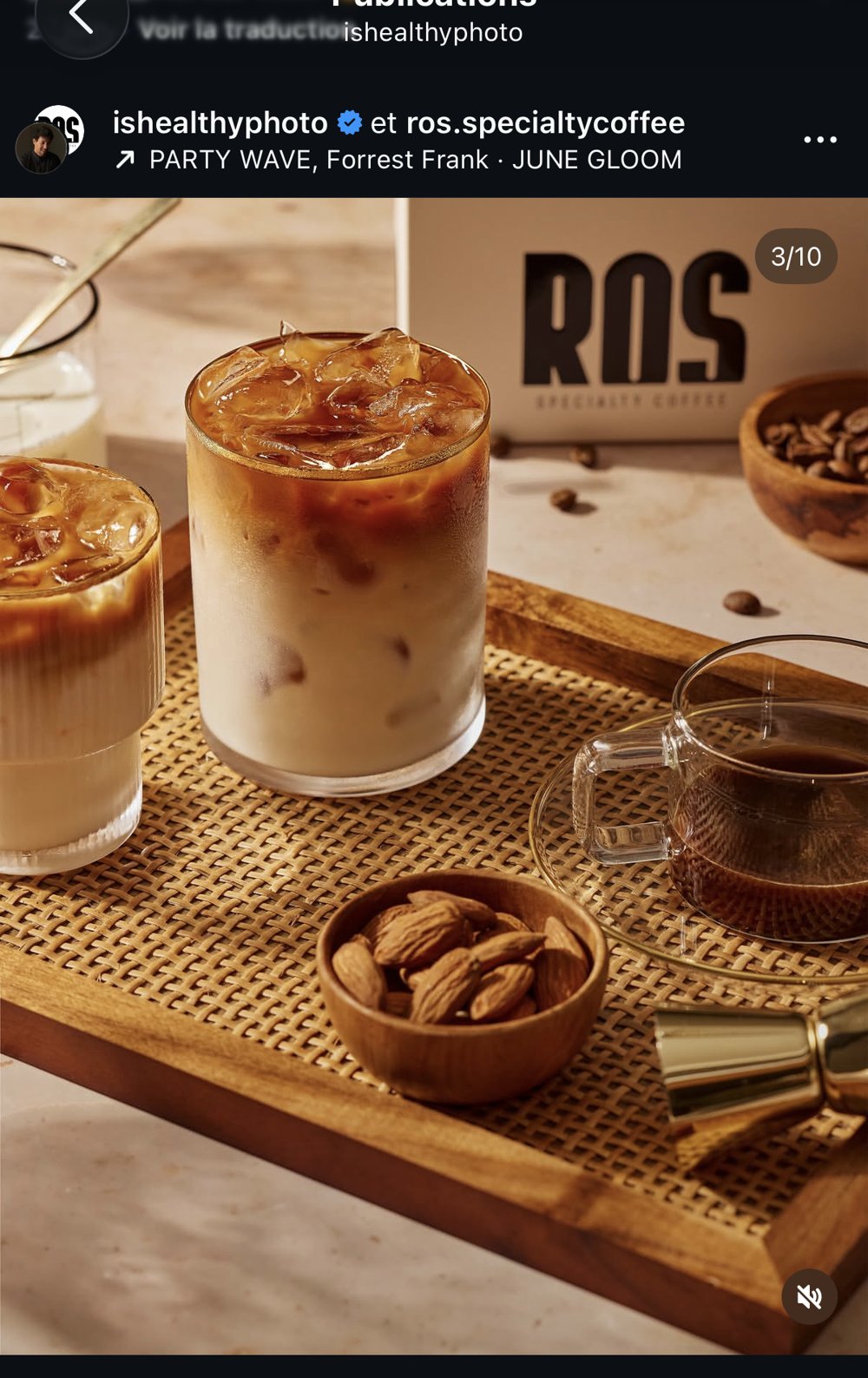 Plateau en rotin avec 3 boissons café glacées, bol d'amandes torréfiées et jigger doré, packshot ROS Specialty Coffee en arrière-plan