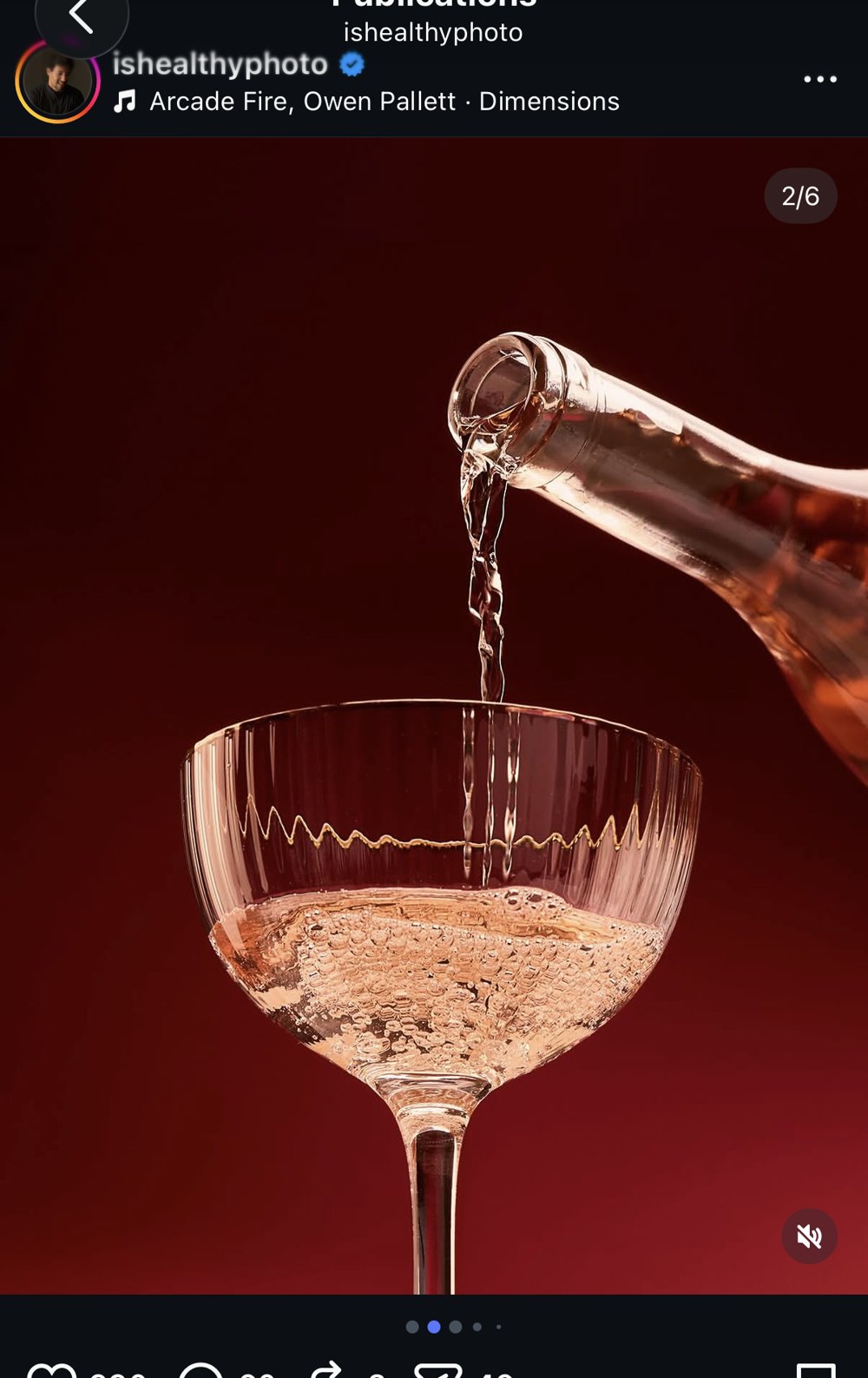 Versement de vin rosé pétillant dans une coupe godet sur fond rouge sombre, contre-jour
