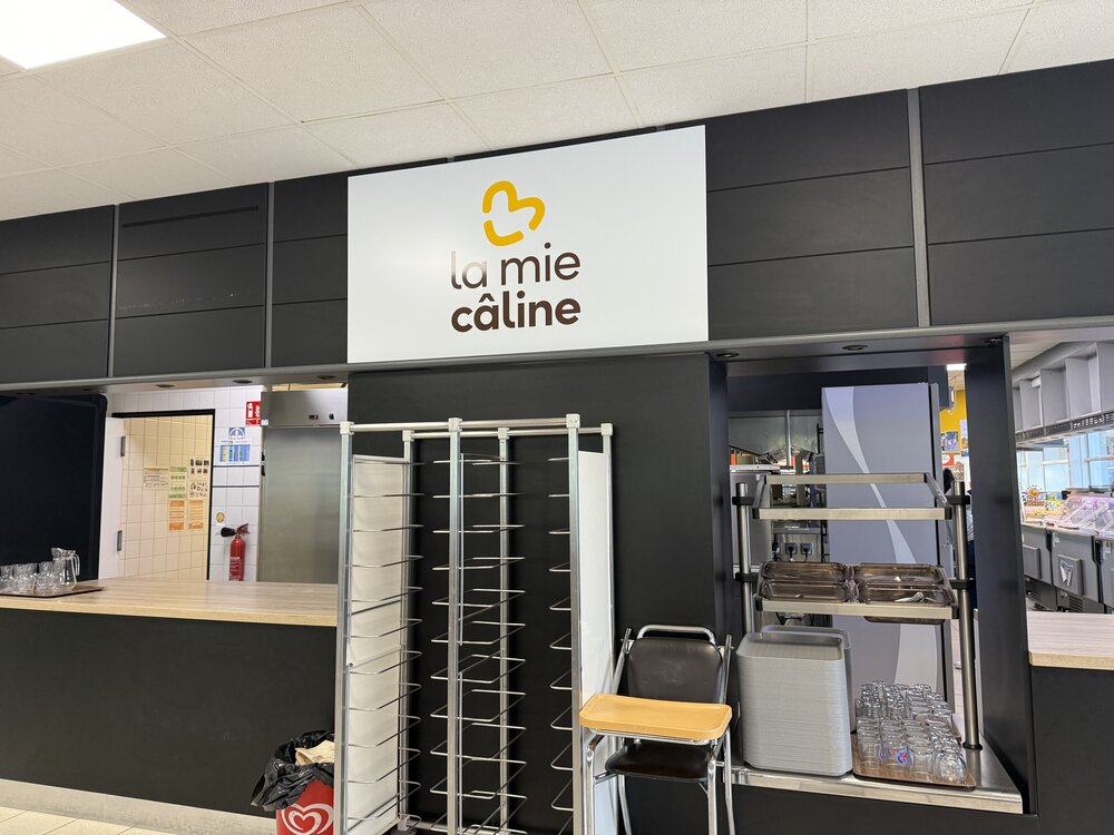 Façade comptoir La Mie Câline — enseigne noire/jaune « cœur » au-dessus du comptoir de service