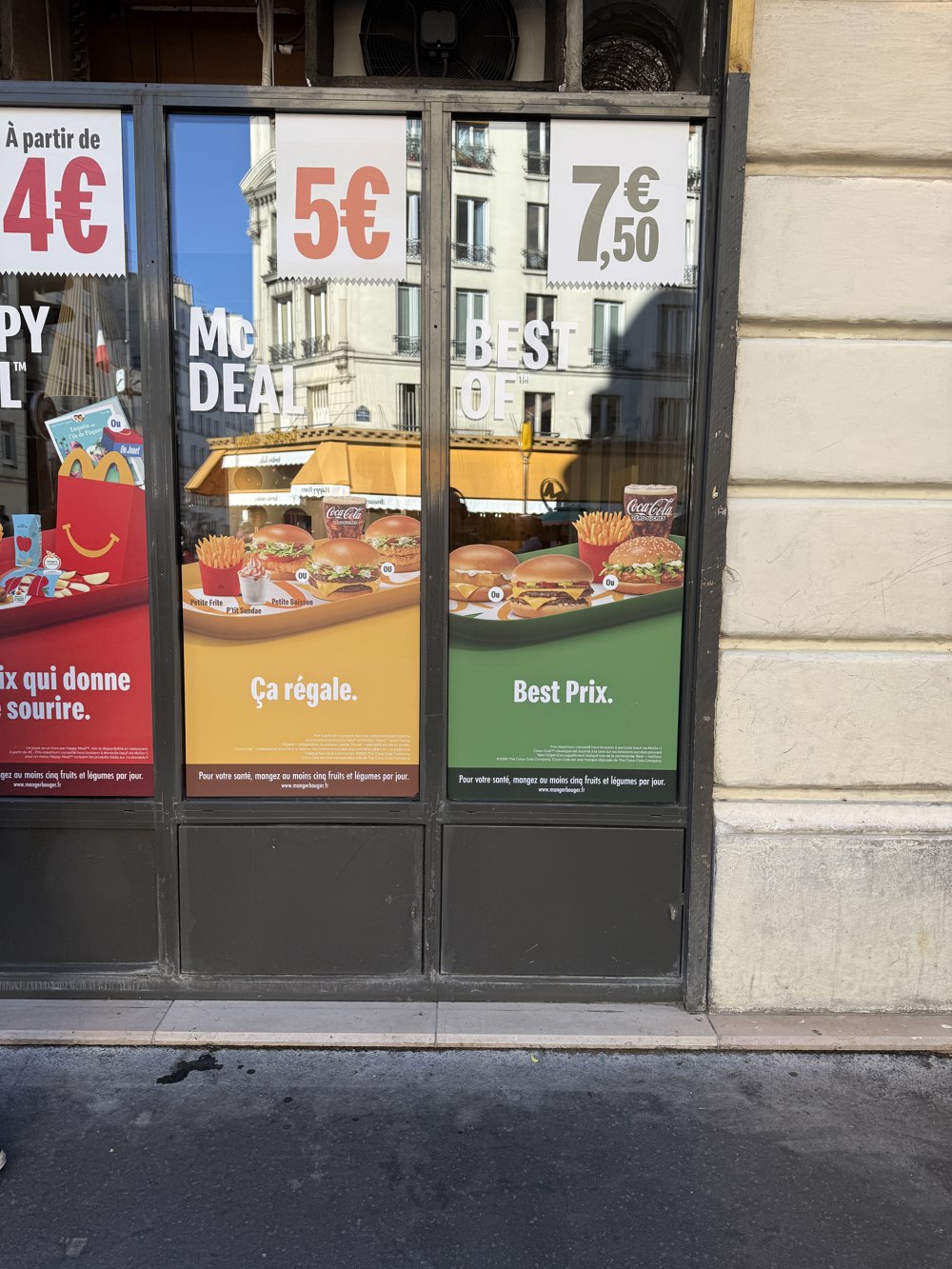 Vitrine à 3 volets tarifaires Happy Meal 4€ / Mc Deal 5€ / Best Of 7,50€, façade McDonald's Paris