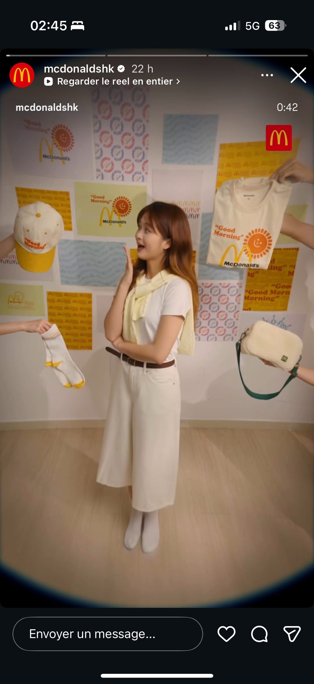 Mannequinat du tee-shirt « Good Morning », casquette et sac bandoulière crème devant un mur de motifs de marque