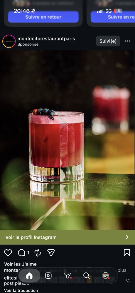Cocktail rouge sur table en verre réfléchissante, terrasse végétalisée en arrière-plan