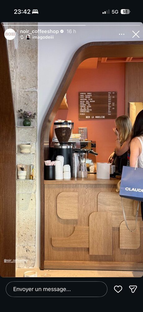 Comptoir vu en contre-plongée sous une arche bois, mur en pierre, menu affiché