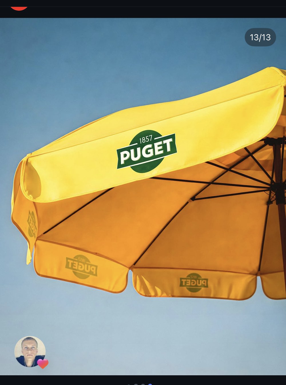 Puget — grand parasol de terrasse jaune moutarde et logo vert « Puget 1857 », publicité sponsorisée pour opération goodies