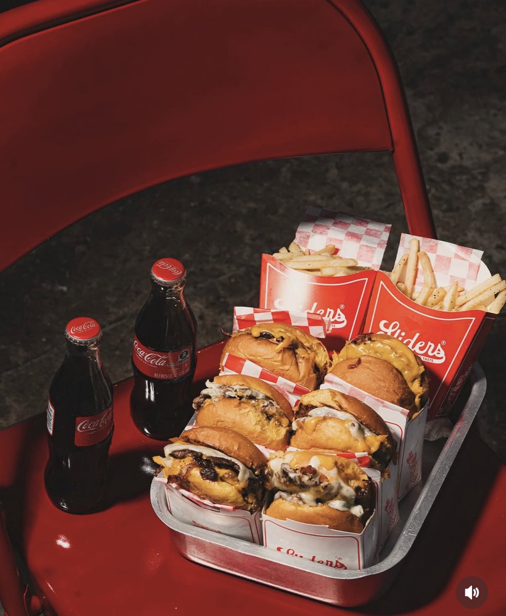 Plateau mini burgers et frites Sliders avec bouteilles Coca-Cola sur chaise metal rouge